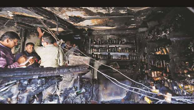 Forensic officials inspect inside a burnt restaurant and bar after a fire killed five people in Bengaluru, yesterday.