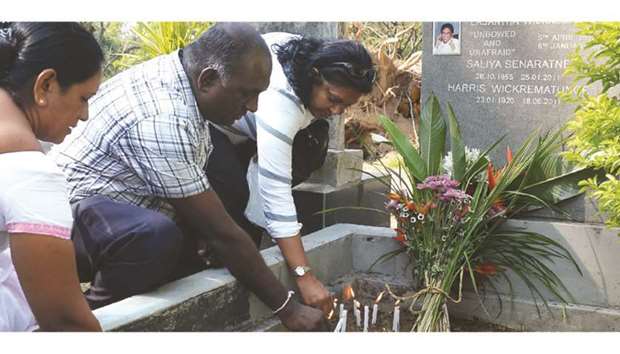 Sri Lankan mourners light candles at the grave of the editor Lasantha Wickrematunga on the ninth anniversary of his murder in Colombo, yesterday. The family of Lankau2019s assassinated editor criticised President Maithripala Sirisenau2019s government yesterday for failing to prosecute the perpetrators nine years since the internationally condemned murder. Wickrematunga was stabbed to death as he drove to his Sunday Leader offices near Colombo days before he was to testify in a corruption case involving the then defence secretary Gotabhaya Rajapakse.