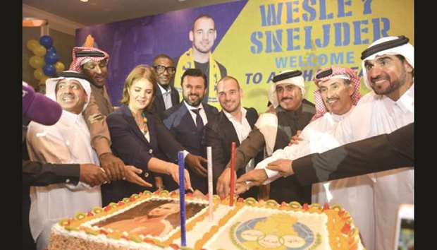 The Netherlandsu2019 ambassador to Qatar Dr Bahia Tahzib-Lie (third from left) helps Dutch star Wesley Sneijder (sixth from left) and Gharafa officials cut a cake at the Four Seasons Hotel in Doha yesterday. Sneijder has signed an 18-month contract with QNB Stars League side Al Gharafa. PICTURE: Noushad Thekkayil