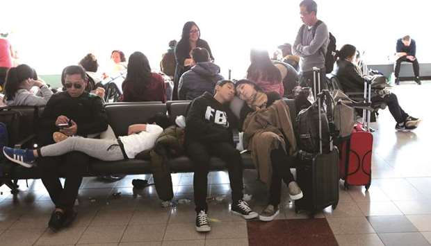 Passengers wait for their flights, delayed by Storm Grayson, at John F Kennedy airport on Sunday.