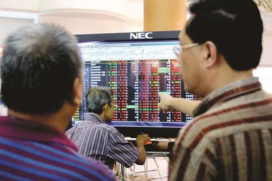 A trader points to the electronic screen at the close of trading at the Kuala Lumpur Stock Exchange (file). Malaysia has four Islamic ETFs listed on the stock exchange in Kuala Lumpur, including the first ever Shariah compliant gold ETF.