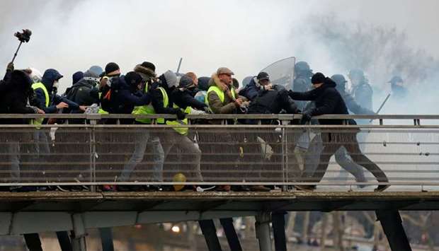 Former French boxing champion, Christophe Dettinger (R), is seen during clashes with French Gendarmes at a demonstration by the ,yellow vests, on the passerelle Leopold-Sedar-Senghor bridge in Paris