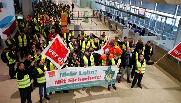 Security personal of the Cologne-Bonn Airport wave flags of German union Verdi during a strike in Cologne
