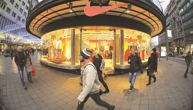 Pedestrians pass a Nike Inc store in Belgrade. Margrethe Vestager, the EUu2019s competition commissioner, announced a probe into the sports equipment maker yesterday, as she criticised nations for allowing companies to set up complex structures u201cthat unduly reduce their taxable profits and give them an unfair advantage.u201d