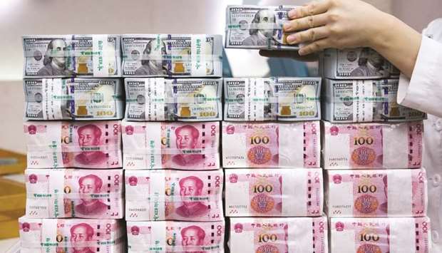 An employee arranges genuine bundles of US one-hundred dollar banknotes and Chinese one-hundred yuan in an arranged photograph at the Counterfeit Notes Response Center of KEB Hana Bank in Seoul (file). Russiau2019s yuan share is at about ten times the average for global central banks, with its total holdings of the currency accounting for about a quarter of world reserves in yuan, according to International Monetary Fund data.