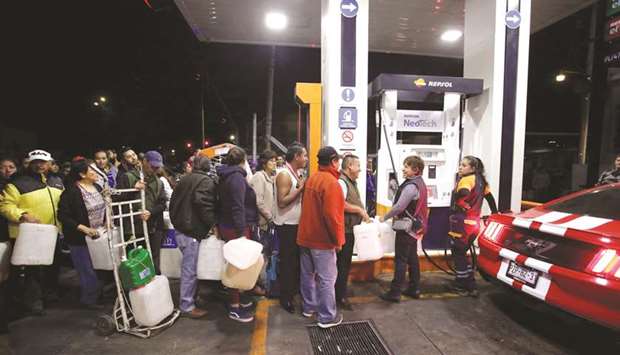 People stand in line at a fuel station in Mexico City.