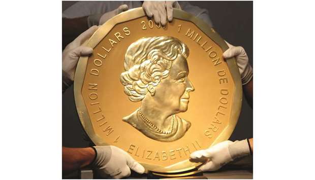 This picture taken in Vienna on June 25, 2010 shows experts of an Austrian art forwarding company holding one of the worldu2019s largest gold coins, a 2007 C$1,000,000 u2018Big Maple Leafu2019. An identical coin was stolen from Berlinu2019s Bode Museum on March 27, 2017.