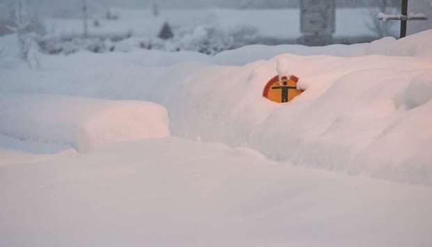 A u2018no trespassu2019 sign is seen buried in the snow at the train station in Berchtesgaden, Germany.