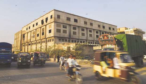 Commuters travel along a road in Karachi past the burnt Baldia garment factory, where at least some 260 people died in 2012. A German court in Dortmund has thrown out the civil lawsuit filed against clothing retailer KiK.