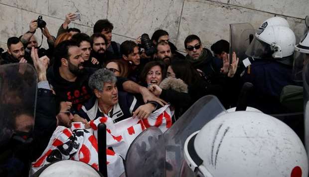 Greek school teachers scuffle with riot police during a demonstration in front of the parliament building against government plans to change hiring procedures in the public sector in Athens, Greece