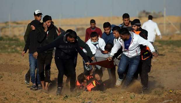 A wounded Palestinian demonstrator is evacuated during a protest at the Israel-Gaza border fence, in the southern Gaza Strip