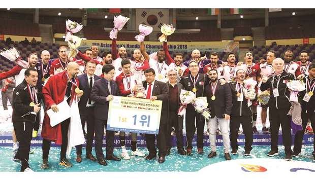 Qatar players, Qatar Handball Federation president Ahmed al-Shaabi, team coach Valero Rivera and other officials celebrate with the trophy after winning the Asian Handball Championship in Suwon, South Korea, in January last year.