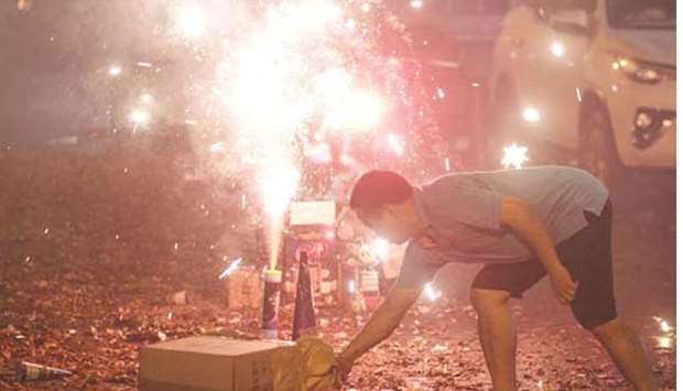 A man lights up firecrackers along a street in Manila during the New Year celebration.