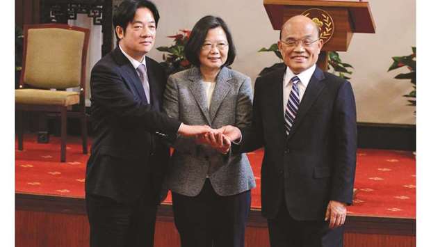 Former premier William Lai, Taiwan President Tsai Ing-wen and new premier Su Tseng-chang join hands after a news conference in Taipei, Taiwan, yesterday.