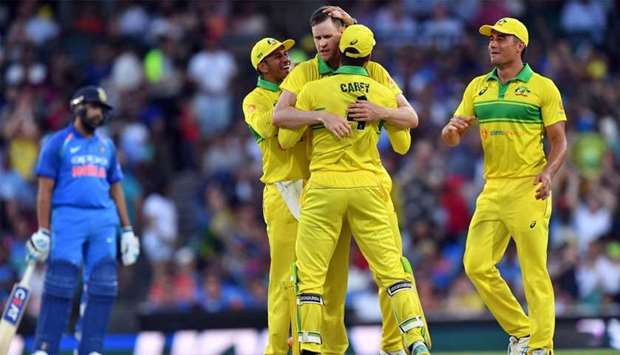 Australia's Jason Behrendorff (C) celebrates taking the wicket of India's Mahendra Singh Dhoni during the first one-day international (ODI) match between Australia and India at the Sydney Cricket Ground