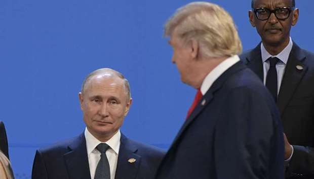 In this file photo taken on November 30, 2018 US President Donald Trump(R), looks at Russia's President Vladimir Putin as they take place for a family photo, during the G20 Leaders' Summit in Buenos Aires, on November 30, 2018
