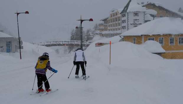 Skiers make their way down a road after heavy snowfall in the Austrian Alpine resort of Obertauern, on Thursday.