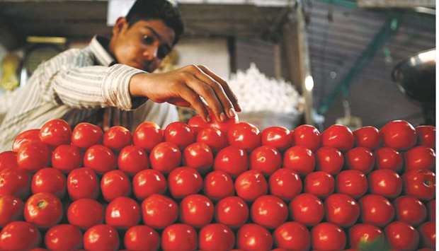 A vendor arranges tomatoes at a vegetable market in Karachi (file). Tomatoes can now be purchased only at Rs40 per kg, which was selling at Rs20-30 per kg. Its wholesale price is Rs20-25 per kg.