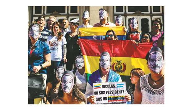 A Venezuelan living in Argentina holds a sign reading u2018Nicolas you are not president, you are a genocidal killeru2019 during a protest against Venezuelan President Nicolas Maduro, at Vaticano Square in Buenos Aires.