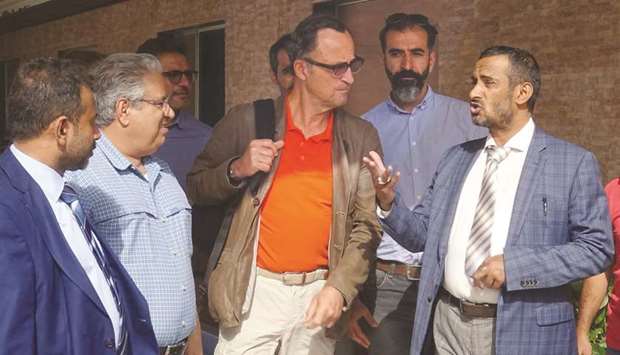 Patrick Cammaert, centre, speaks with an official in the port city of Hodeidah yesterday.