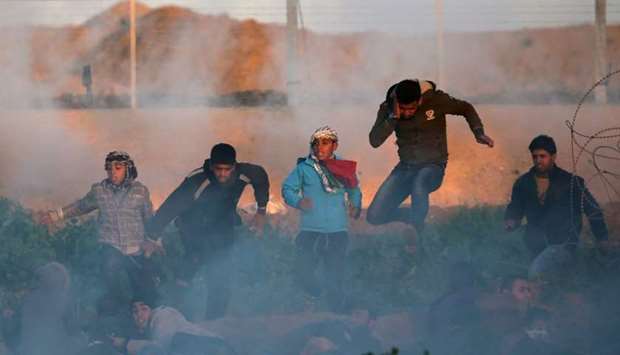 Palestinians run for cover from Israeli gunfire and tear gas during a protest at the Israel-Gaza border fence, in the southern Gaza Strip on January 11.