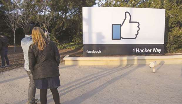 Pedestrians take photographs of signage displayed outside Facebook Inc headquarters in Menlo Park, California. Facebook, which has been criticised for enabling manipulation of its news feed, has consistently said it does not want to be considered a media organisation that makes editorial decisions but wants to support journalism and efforts to fight misinformation.