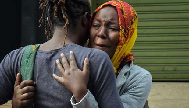 A woman cries in the arms of a relative in Nairobi while identifying the bodies of the victims after a blast followed by a gun battle that rocked the upmarket hotel complex