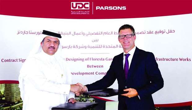 Al-Othman and Welch shaking hands after signing the agreement