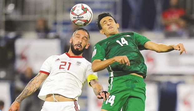 Iranu2019s Ashkan Dejagah (left) and Iraqu2019s Amjad Attwan go for a header during the AFC Asian Cup Group D match at Al-Maktoum Stadium in Dubai. (Reuters)