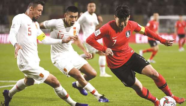 Chinau2019s Linpeng Zhang (left) fights for the ball with South Koreau2019s Son Heung-min during the AFC Asian Cup group C match in Abu Dhabi yesterday. (AFP)