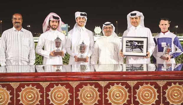 Qatar Racing and Equestrian Club (QREC) Racing manager Abdulla Rashid al-Kubaisi (third from right) with the winners of the Umm Al Afai Cup after Receding Waves won the feature at Al Rayyan Park yesterday. PICTURES: Juhaim