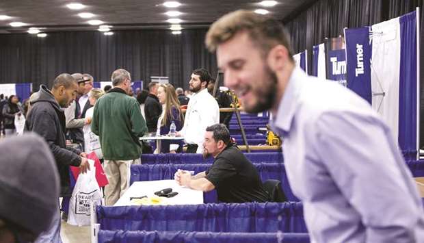 Job seekers speak with representatives during a career expo event in Detroit. The four-week moving average of initial claims, considered a better measure of labour market trends as it irons out week-to-week volatility, slipped 1,000 to 220,750 last week, the Labour Department said yesterday.