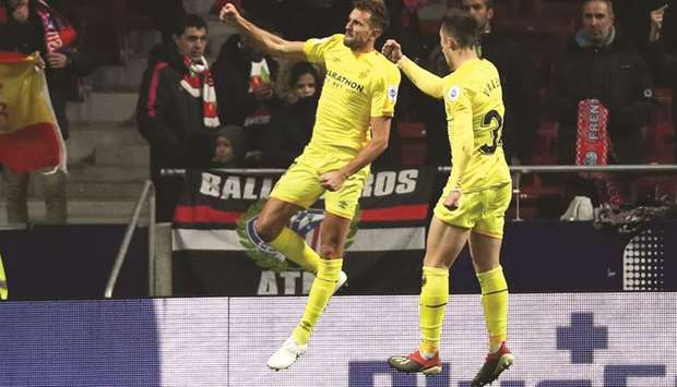 Gironau2019s Cristhian Stuani (left) celebrates with teammate Valery Fernandez after scoring against Atletico Madrid in Copa del Rey. (Reuters)
