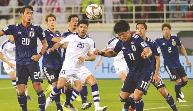 Japan forward Koya Kitagawa (R) heads the ball during their Asian Cup group F match against Uzbekistan in Al Ain yesterday.