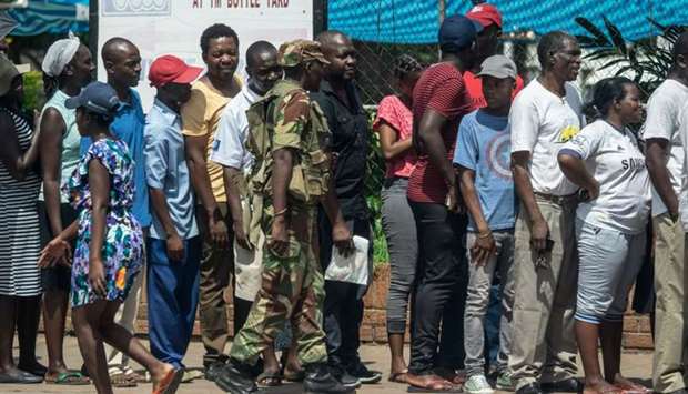 A Zimbabwean soldier watches a shopping queue, in Bulawayo
