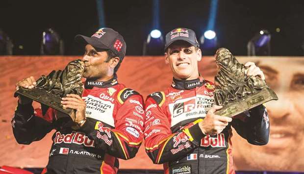 Nasser al-Attiyah of Qatar (L) and co-driver Matthieu Baumel (R) of France celebrate on the 2019 Dakar Rally podium in Lima after their victory in the Dakar Rally on Thursday