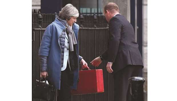 Prime Minister Theresa May carries her red ministerial box as she leaves from the rear of 10 Downing Street in central London yesterday.