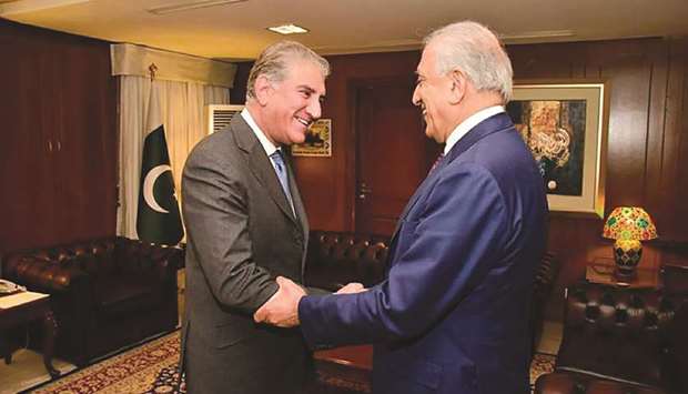 In this handout photo released by the ministry of foreign affairs, Foreign Minister Shah Mahmood Qureshi greets US envoy Zalmay Khalilzad at the ministry in Islamabad.