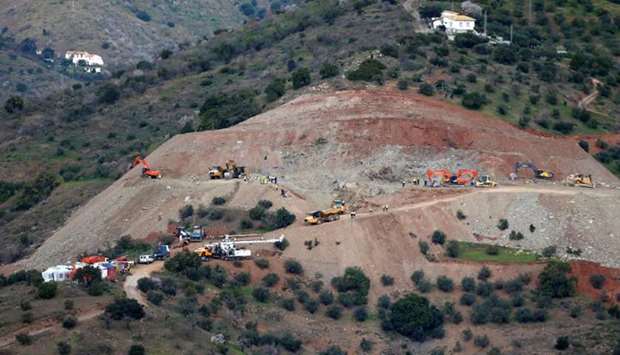 An idle drill (bottom) is seen next to diggers and trucks removing sand at the area where Julen, a Spanish two-year-old boy fell into a deep well six days ago. Reuters