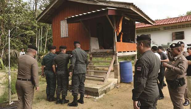 Police and soldiers inspect a shelter inside Rattanaupap temple compound where two Buddhist monks were wounded while two more monks were killed in the temple in Narathiwat province yesterday following an attack by black-clad gunmen.