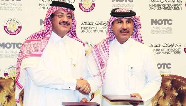 Hassan al-Hail, advisor to HE the Minister of Transport and Communications Jassim Seif Ahmed al-Sulaiti, and Qatar Post chairman and managing director Faleh al-Naemi shake hands after signing the agreement. PICTURE: Anas Khalid.