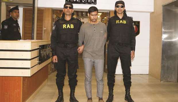 The Rapid Action Battalion (RAB) escort arrested suspected militant Mamunur Rashid (centre) in Dhaka yesterday.