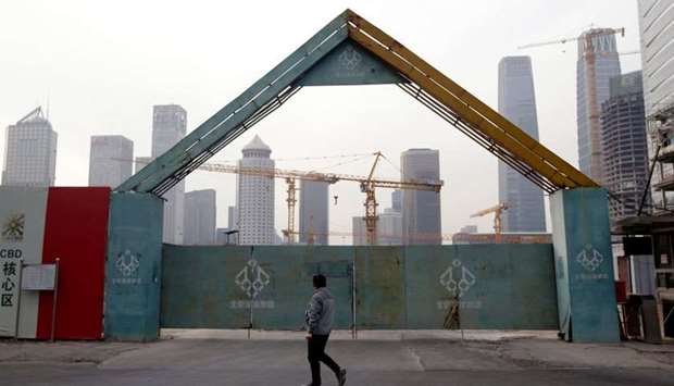 A man walks outside the construction sites in Beijing's central business area