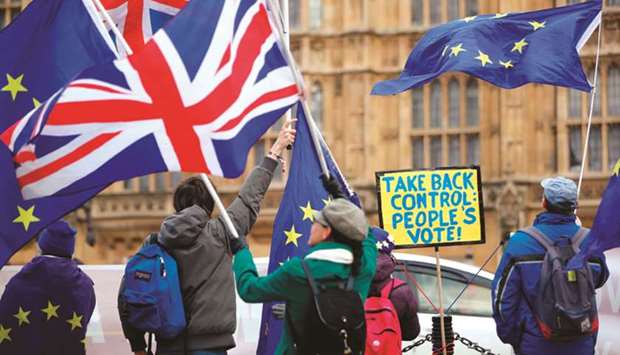 Anti-Brexit activists wave EU and Union flags as they demonstrate outside the Houses of Parliament in central London yesterday.