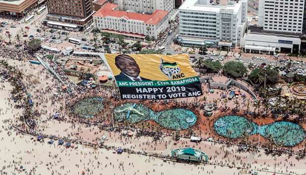 This aerial view shows a helicopter flying a giant flag from the South African ruling party African National Congress (ANC) urging people to register to vote for the upcoming elections as thousands of revellers and holidaymakers gather at the North Pier Beach during New Year celebrations in Durban, yesterday.