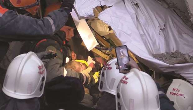 This handout picture released by the Russian emergencies ministry shows rescuers moving the baby from the rubble of the residential building in Magnitogorsk.