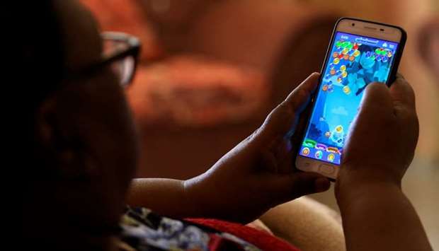 A Sudanese man holds his phone and plays games in Khartoum, Sudan.