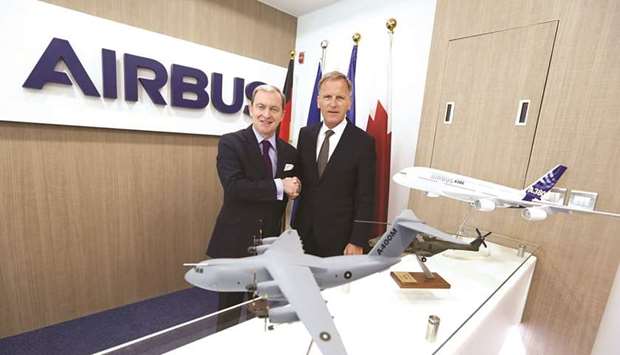 French ambassador to Qatar Franck Gellet and German ambassador Hans-Udo Muzel shake hands while viewing scale models of Airbus aircraft.