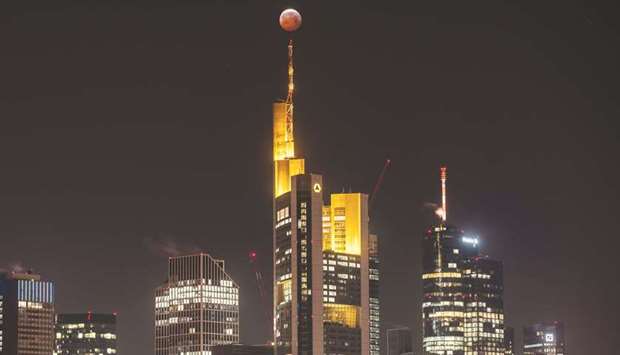 The moon is seen above the Frankfurt skyline during a lunar eclipse.