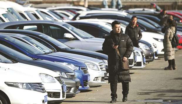 A man walks through a used car sales yard in Beijing. Chinau2019s economy grew at its slowest pace in almost three decades in 2018, losing more steam in the last quarter as it battles a massive debt pile and a US trade war, official data showed yesterday.